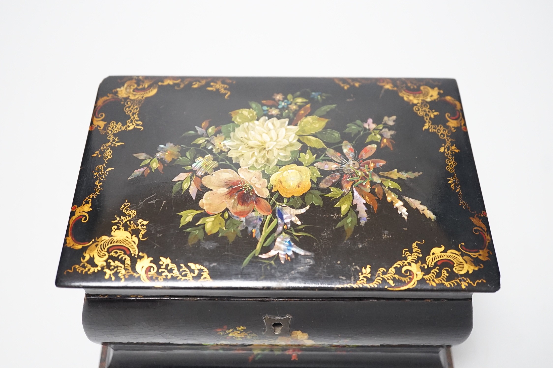 A Victorian papier-mâché bombé tea caddy with painted floral and gilt decoration. 12.5cm high